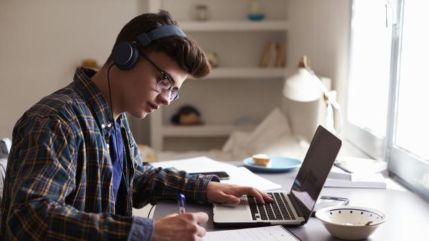 image of a man listening to music in front of a desk.