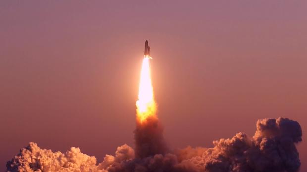 a space rocket lifting off with plume of smoke