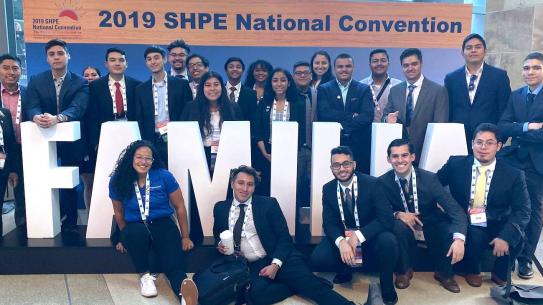 SHPE student group in front of "Familia" sign