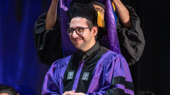 Ph.D. student receiving hood at ceremony