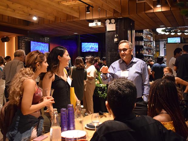 two female Ph.D. students talking with faculty in a restaurant