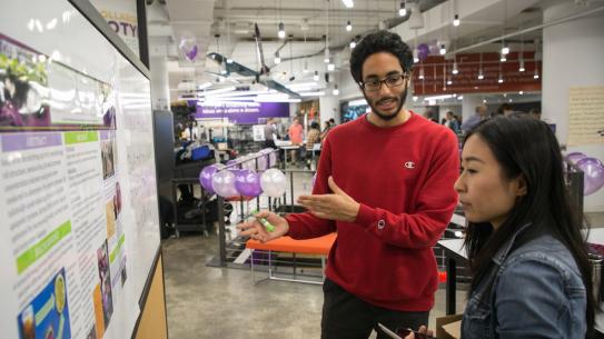 Students explaining research poster