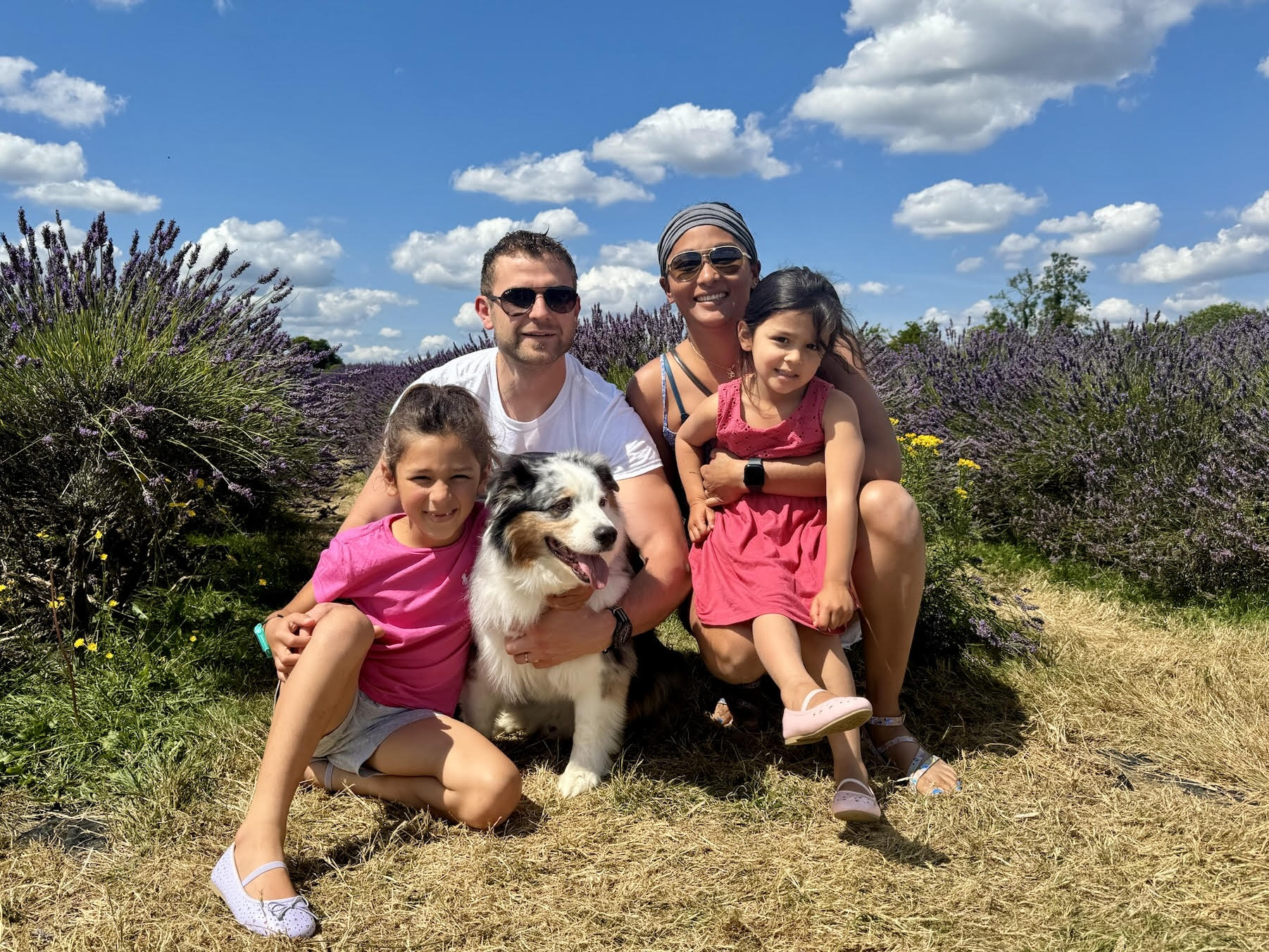 smiling family of four outside in field